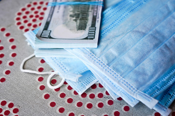 Medical masks with money. American dollars with protective masks. A fan of dollars with a fan of medical masks.