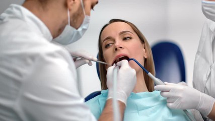 Woman patient with caries visit dentist at stomatology clinic. Close up shot on 4k RED camera