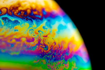 Psychedelic abstract planet from soap bubble, Light refraction on a soap bubble, Macro Close Up in soap bubble. Rainbow colors on a black background. Model of Space or planets universe cosmic galaxy. © Epic Vision