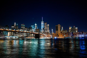 Fototapeta na wymiar Night view of New York through the Hudson. Brooklyn Bridge and the International Trade Center.