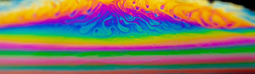 Psychedelic abstract planet from soap bubble, Light refraction on a soap bubble, Macro Close Up in soap bubble. Rainbow colors on a black background. Model of Space or planets universe cosmic galaxy.