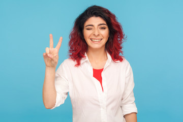 Portrait of happy successful hipster woman with fancy red hair winking playfully to camera and...