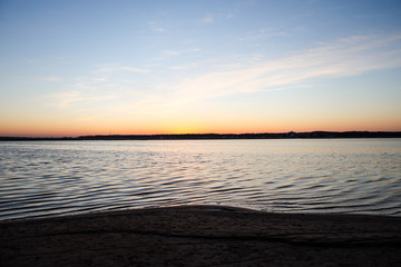 Beautiful landscape view with river slowly flowing with small waves during the sunset.