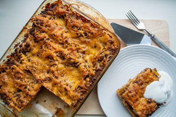 Juicy meat lasagna, cassic dish of Italian cuisine with dough, meat and sauce with creamy soft mozzarella cheese.