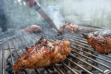 Grilled delicious chicken meat in process of cooking in outdoor at home balcony, summer time, closeup, details