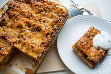 Juicy meat lasagna, cassic dish of Italian cuisine with dough, meat and sauce with creamy soft mozzarella cheese.