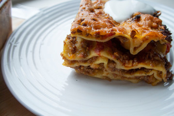 Juicy meat lasagna, cassic dish of Italian cuisine with dough, meat and sauce with creamy soft mozzarella cheese.