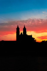 Obraz premium Silhouette of Cathedral of Magdeburg during bloody red sunset at Spring in Magdeburg, Germany, postcard