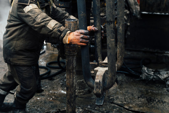 Offshore oil rig worker prepare tool and equipment for perforation oil and gas well at wellhead platform. Making up a drill pipe connection. A view for drill pipe connection from between the stands.