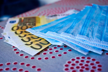 Obraz premium Medical masks with money. European money with protective masks. Fan EURO with a fan of medical masks.