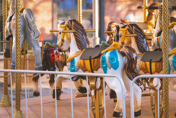 Colorful children carousel with horses in an amusement park. Empty old fashioned carousel.