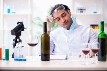 Male chemist examining wine samples at lab