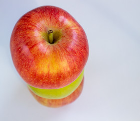 Three apples, one green and two red-yellow on a light background.