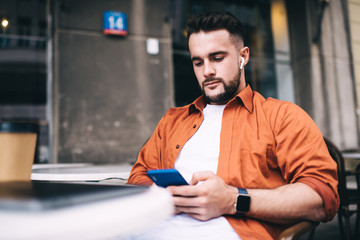 Busy guy surfing internet using smartphone