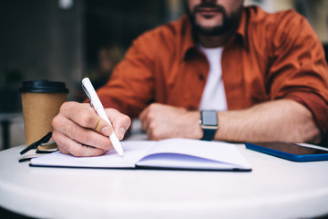Faceless businessman writing notes down