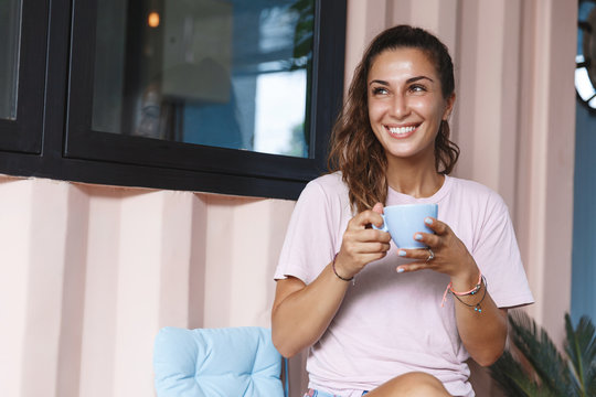 Sweet Home, Leisure And Happy Moment Concept. Smiling Woman Drinking Coffee, Hold Tea Cup And Look Away, Enjoying View Outdoors On Nature While Self-quarantine, Sit House Porch During Lockdown