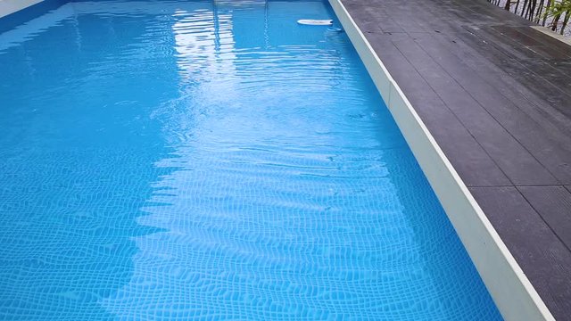 Water Caustic Background. water waves and lines of blue tile in hotel swimming pool.