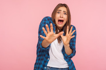 I'm afraid! Portrait of shocked scared girl in checkered shirt screaming in horror and fear,...