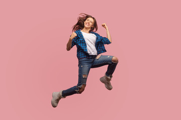 Full length of overjoyed ecstatic stylish girl jumping in air, gesturing i did it, celebrating...