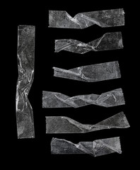 set of transparent adhesive tape or strips isolated on black background, crumpled plastic sticky...