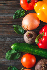 peppers, green cucumbers, garlic, beetroot, tomato, onions, spinach  on a brown wooden background top view, fresh vegetables,  close up