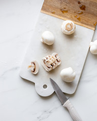 Fresh sliced champignon mushrooms on cutting board.