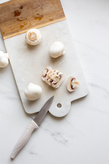 Fresh sliced champignon mushrooms on cutting board.