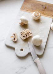 Fototapeta na wymiar Fresh sliced champignon mushrooms on cutting board.