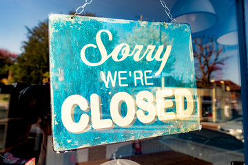 Sorry We're Closed' sign in shop window 
