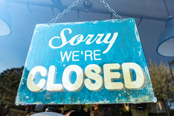 Sorry We're Closed' sign in shop window 