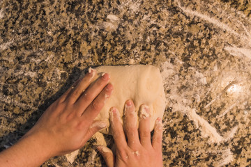 woman hands kneading dough to make bread