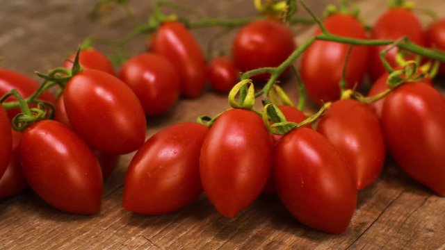 Bunch of Piccadilly tomatoes on wooden table.
