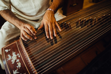 Hands of a musician playing guzheng, Chinese musical instrument
