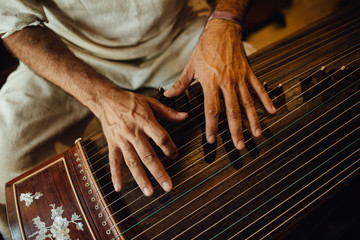 Hands of a musician playing guzheng, Chinese musical instrument