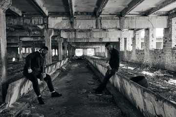 Two guys in an abandoned factory, wearing mask for protection from corona virus covid-19