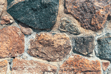 Background of old stone wall with stones of different sizes and colors.