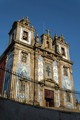 Fototapeta na wymiar Santo Ildefonso church with arrow fence. Blue relegious tiles. Cloudy sky. Porto