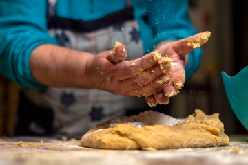 Woman's hands preparing the dough for the fried donuts of Easter