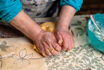 Woman's hands preparing the dough for the fried donuts of Easter