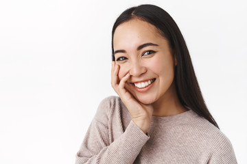Happiness, people and skincare concept. Cheerful tender and romantic young silly asian woman with...