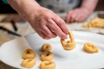 Woman's hands preparing the dough for the fried donuts of Easter