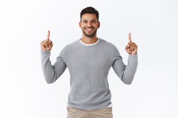 Confident, friendly attractive, charismatic bearded man smiling satisfied and cheerful, pointing...