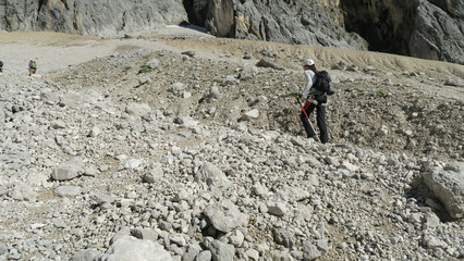 Tourist with equipment on a mountain trail in the Alps