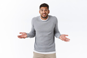 Handsome silly forgetful guy feeling sorry, apologizing late meeting, spread hands sideways...