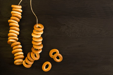 Bunch of bagels on the black wooden background. Copy space. Closeup.