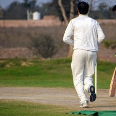 Full length of cricketer playing on field during sunny day, Cricketer on the field in action,...