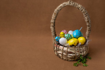 basket with colored Easter eggs on a brown background. colored eggs of Easter eggs
