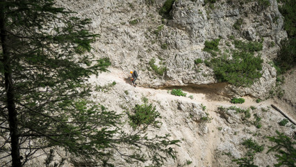 Going through a difficult trail in the full inventory located in the gorge. Dolomites in the Alps.