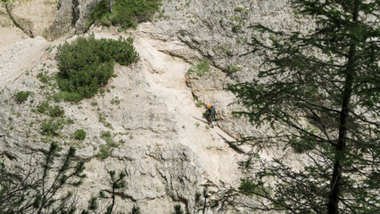 Going through a difficult trail in the full inventory located in the gorge. Dolomites in the Alps.