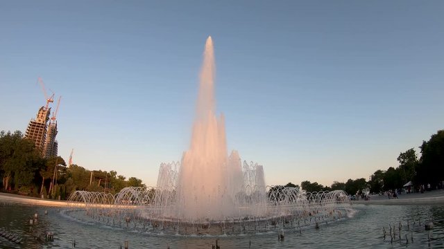 Baku, Azerbaijan - July 2019: Fountain in Baku National Seaside Park in front of the parliement building in the evening